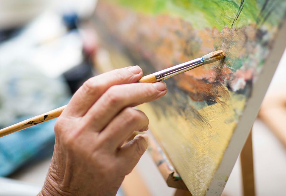 older person paining at ACH art group