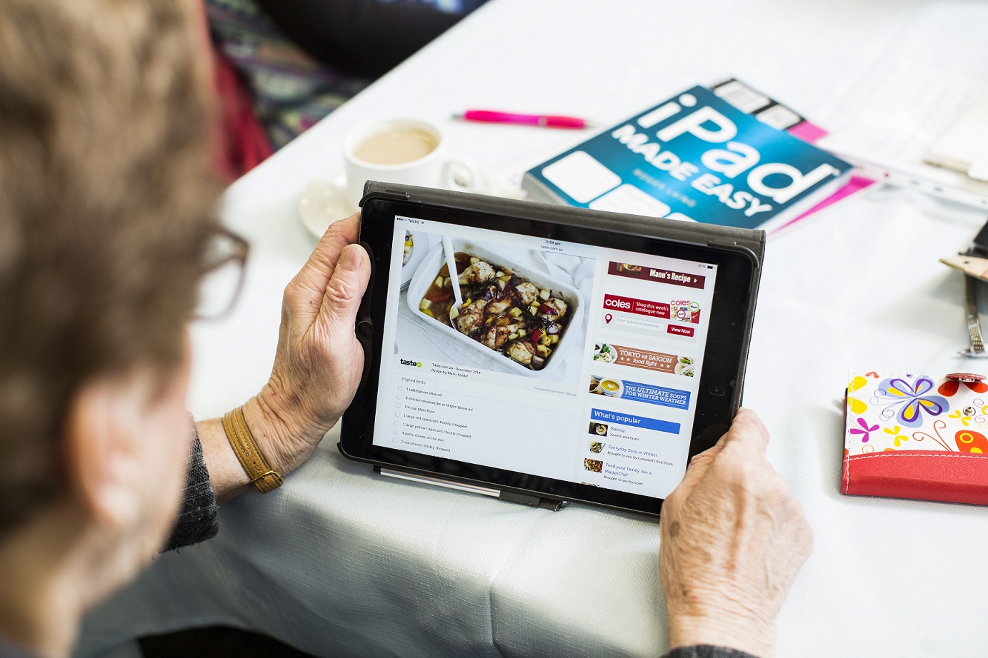 older person using ipad to research recipes