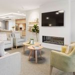 Cosy lounge with fireplace, seating and TV at Healthia Residential Care Home