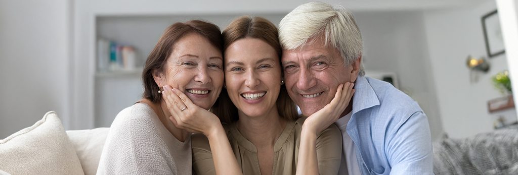 oldest daughter with her parents posing for a photo