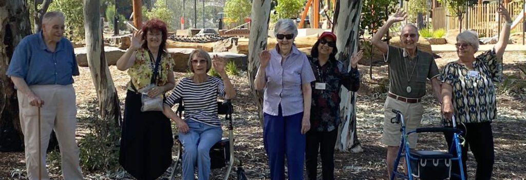 Going on a bus trip is one of the things that make Milpara residents happy. Here's a photo of them in a park, waving and having their photo taken for the 'Happiness Project'.
