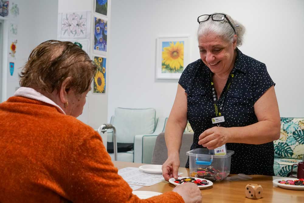 Milpara Residential Care Home Memory Unit - resident engaging in n activity with staff member