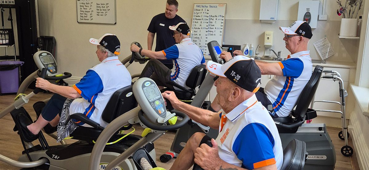 Photo from Kapara Residential Care Home gym, with residents participating in a cycling challenge.