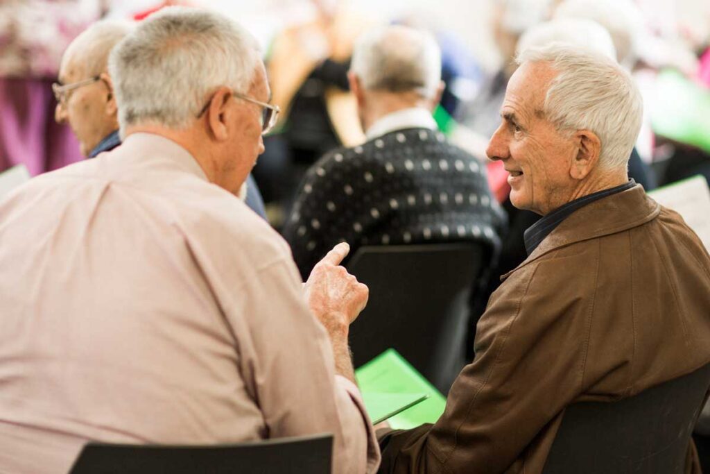Two men in conversation about Sing for Joy Choir