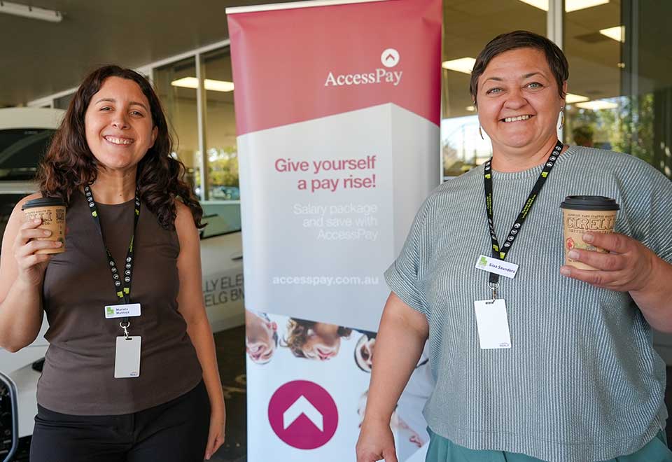 AccessPay is one of the benefits offered at ACH Group, here is an event photo capturing two happy ACH Group employees enjoying free coffee