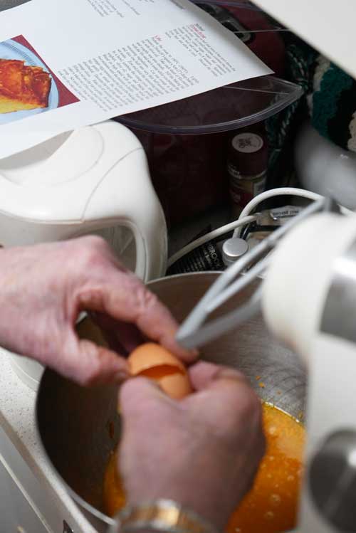 Adding eggs in the mixture for orange cake