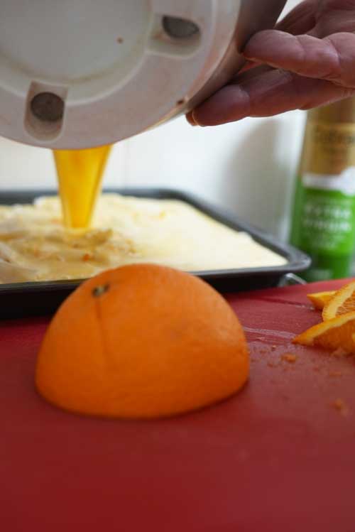 Pouring mixture over filo pastry in baking dish.