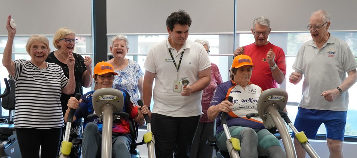 Health studio customers and workforce cheering as the Cycle Challenge begins.