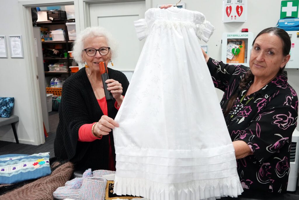 Jana shows a range of bespoke handcrafted garments, while Support Worker Sandra admires the intricate detail and care behind each piece.